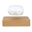 Empty white geometric planter suspended above its light wood-effect square magnetic base on a white background