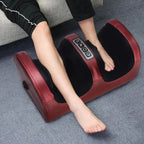 Person using a red and black foot massage device on a gray floor.