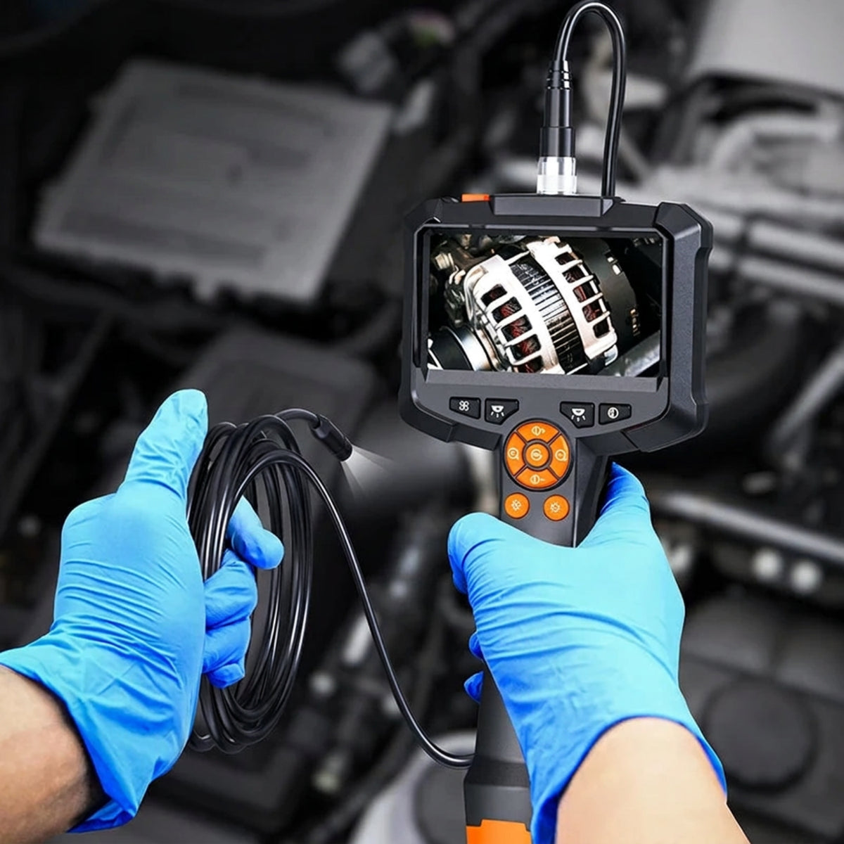 Handheld inspection camera being used in a vehicle workshop with its live image shown on the built-in screen.