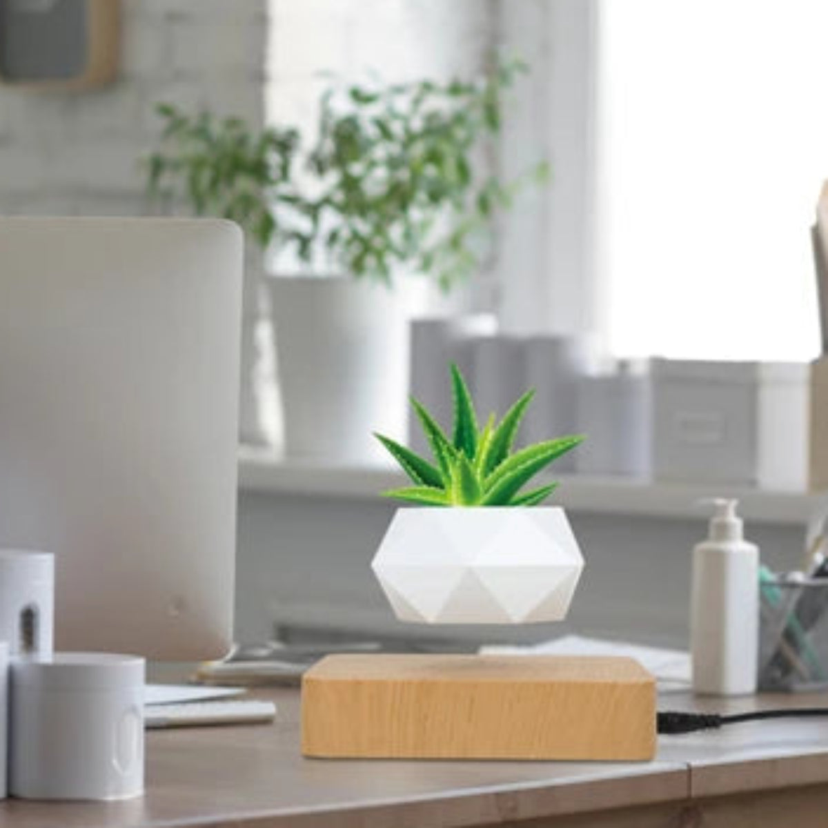 Illustration of the white floating planter and light wood-effect base on a bright desk; plant and room accessories are not included