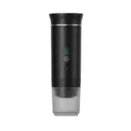 Black self-heating portable espresso maker with digital display and attached ribbed cup on a clean white background