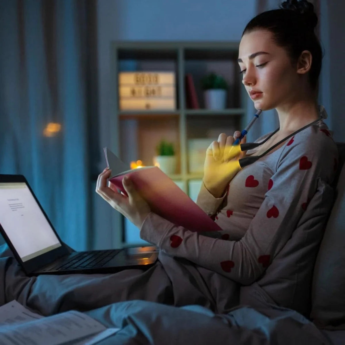 Person using the neck reading light while reading a book in the evening.