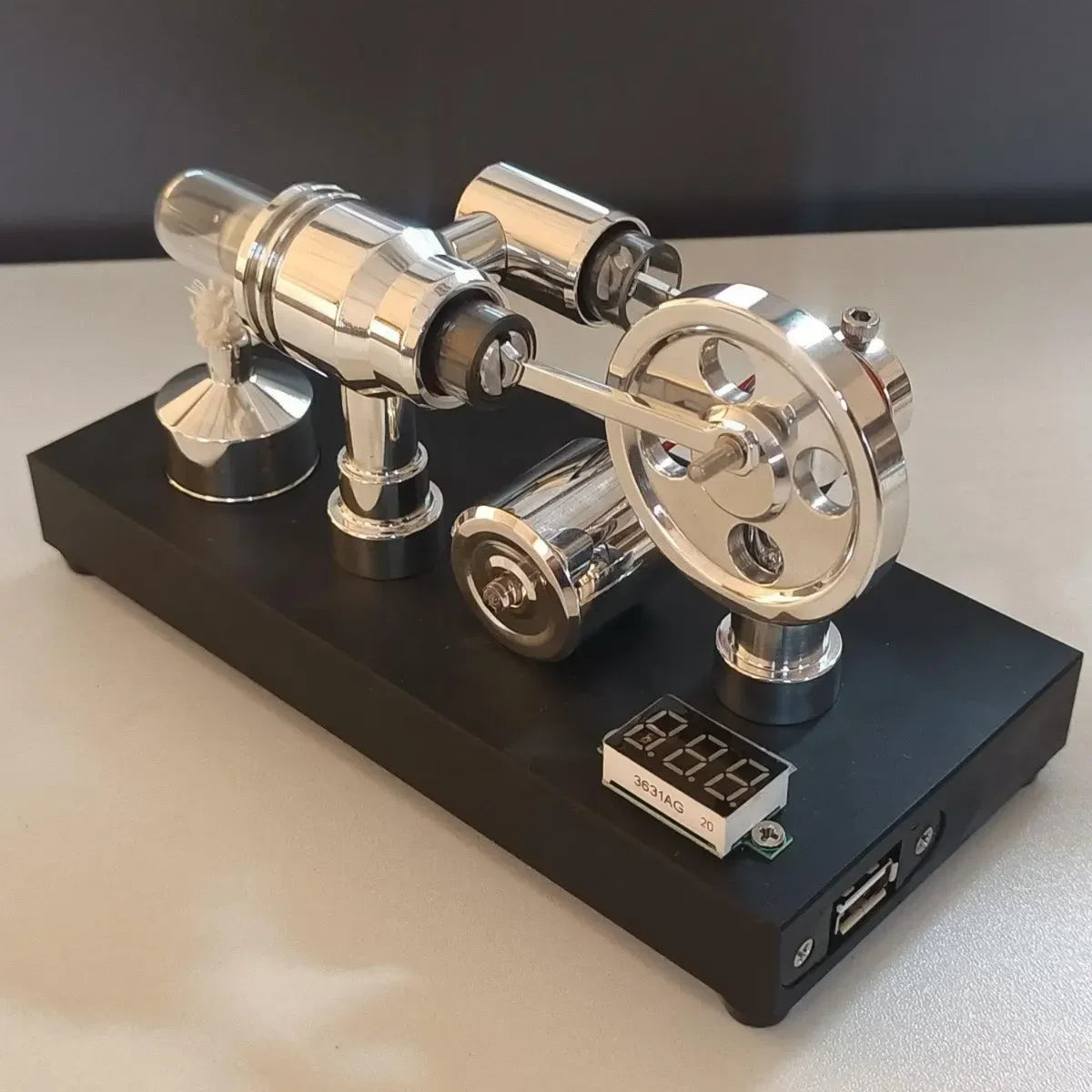 Reverse angle of the polished Stirling engine showing the flywheel and generator on the black base