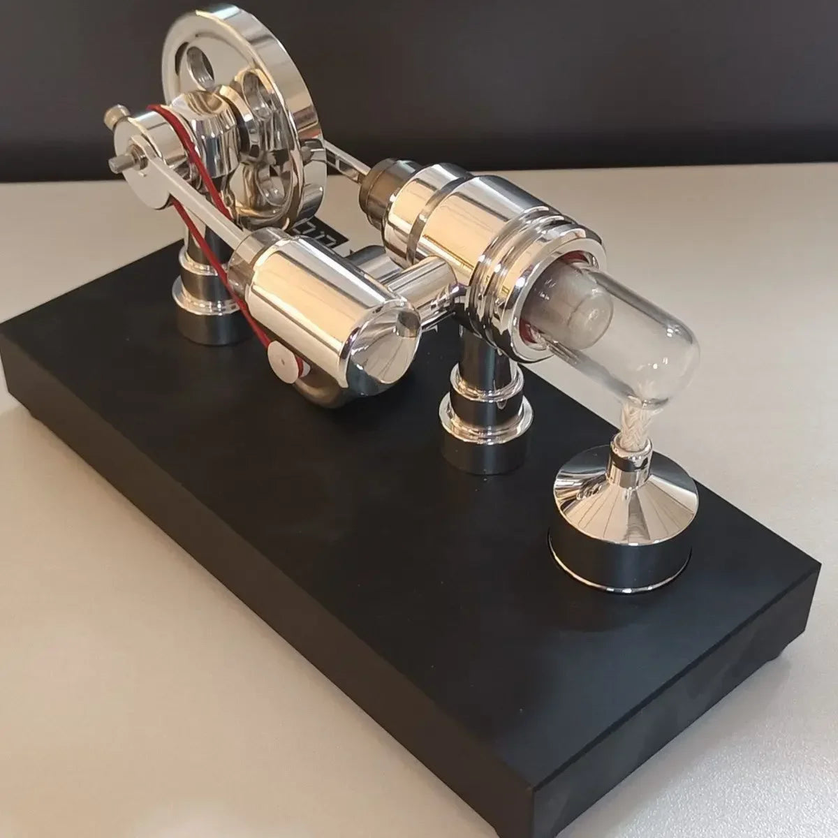 Rear angle of the polished Stirling engine with generator, burner and black display base
